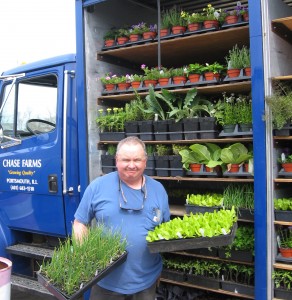 Harry with his vegetable and herb plants by the Blue Begonia Bus